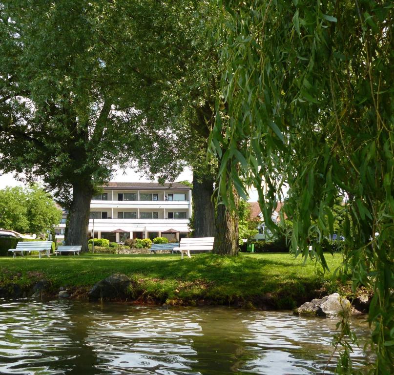 于伯林根西帕加尔尼酒店的一座有河流和树木的建筑