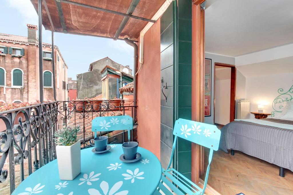 威尼斯Via Garibaldi-Gigli Biennale Terrace的客房设有阳台,配有一张床和两把椅子