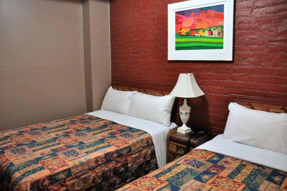 蒙特利尔圣凯瑟琳酒店的酒店客房,设有两张床和一盏灯