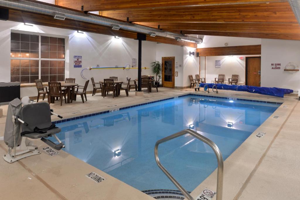 西黄石斯基蔻驰酒店的一个带桌椅的大型游泳池