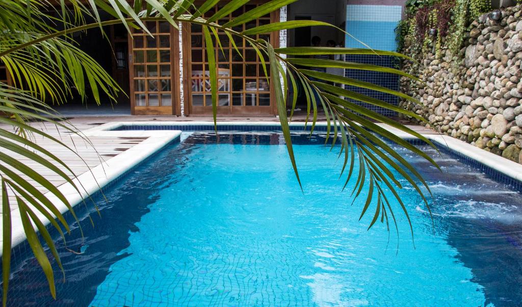 坎布里Pousada Camburi的一座棕榈树游泳池,毗邻一座建筑