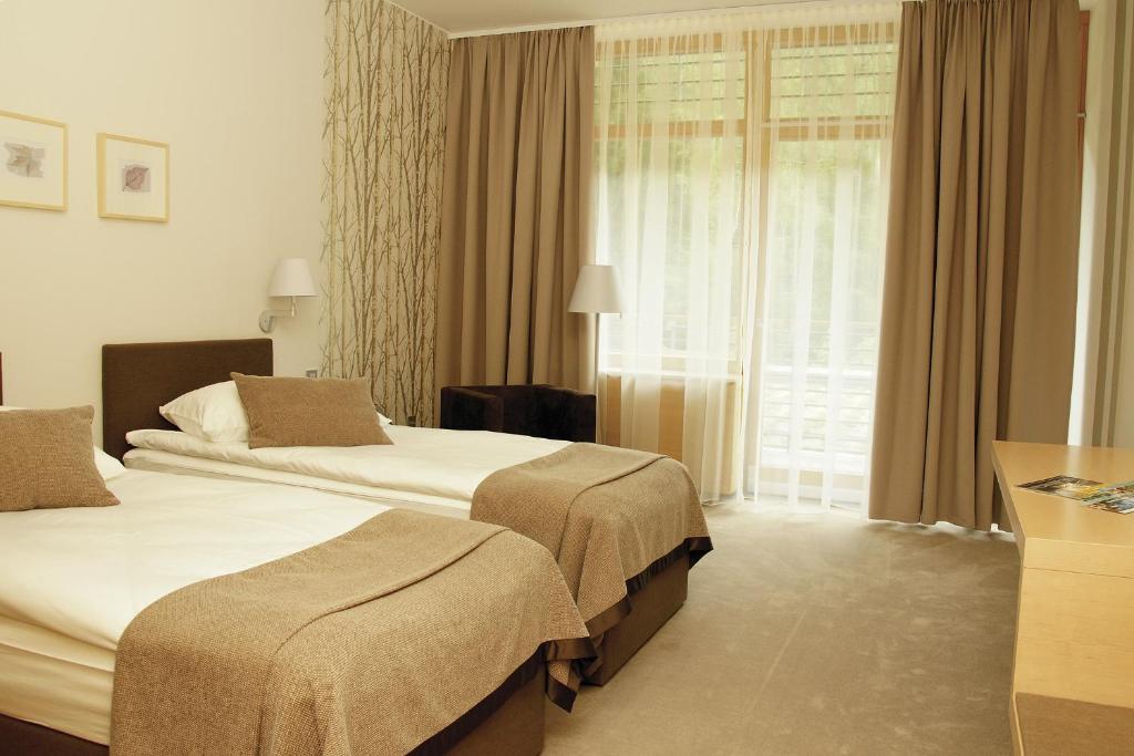 克拉尼斯卡戈拉Špik Alpine Resort的酒店客房设有两张床和窗户。