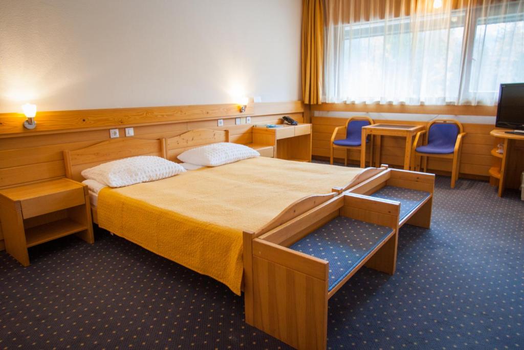 克拉尼斯卡戈拉Hotel Špik的一间卧室配有一张大床和两把椅子
