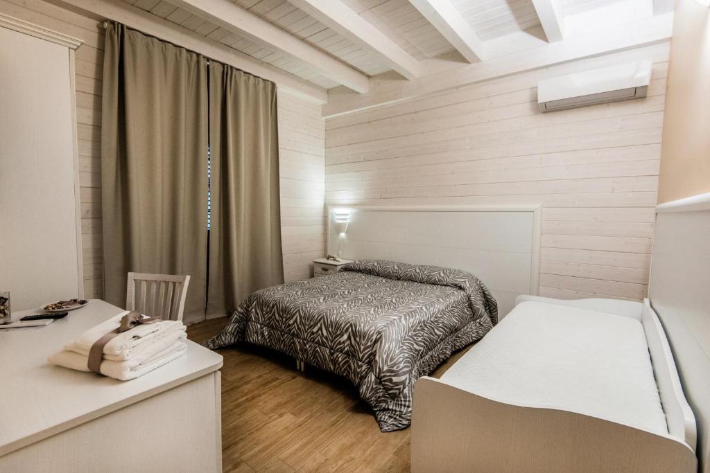 吉诺萨滨海Le Camelie的一间小卧室,配有一张床和一张书桌