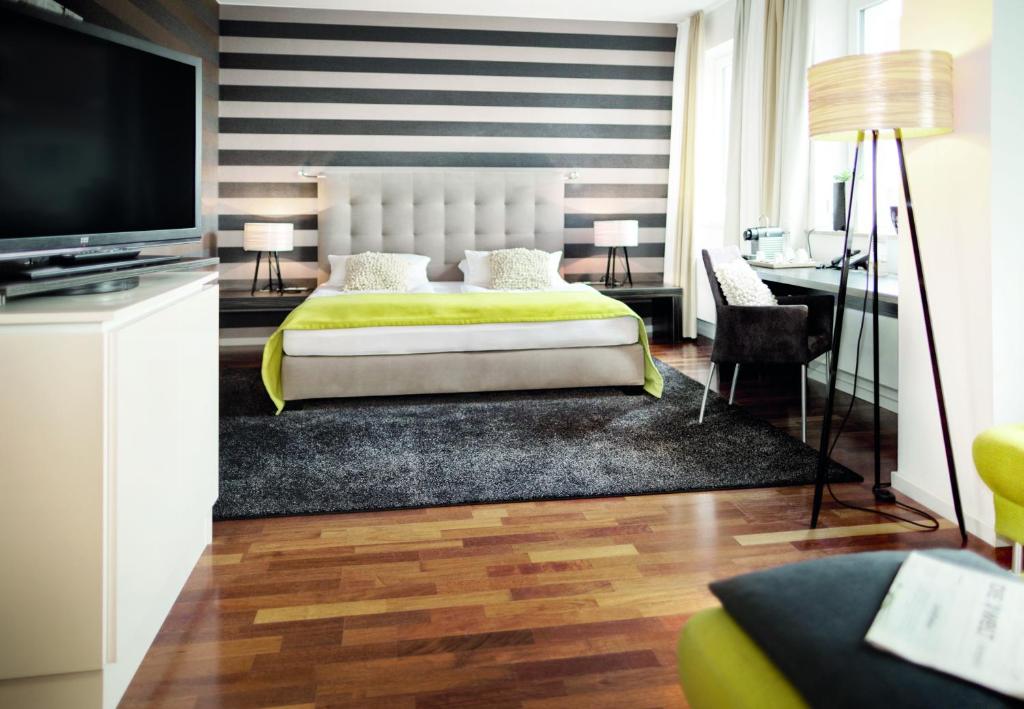 巴特恩豪森博塞城市酒店的一间卧室配有一张大床和电视