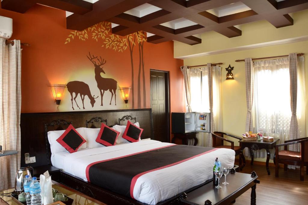 加德满都卡萨曼达精品酒店的卧室配有一张大床,墙上挂着鹿