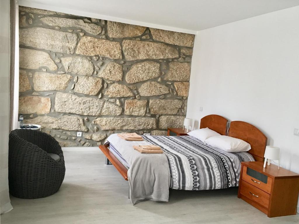 波尔图Campanhã Boutique Station的一间卧室设有一张床和石墙