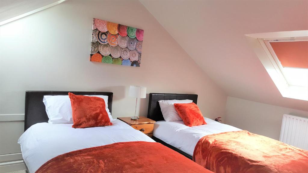 史云顿Swindon City Centre Duplex - EnterCloud9SA的两张睡床彼此相邻,位于一个房间里