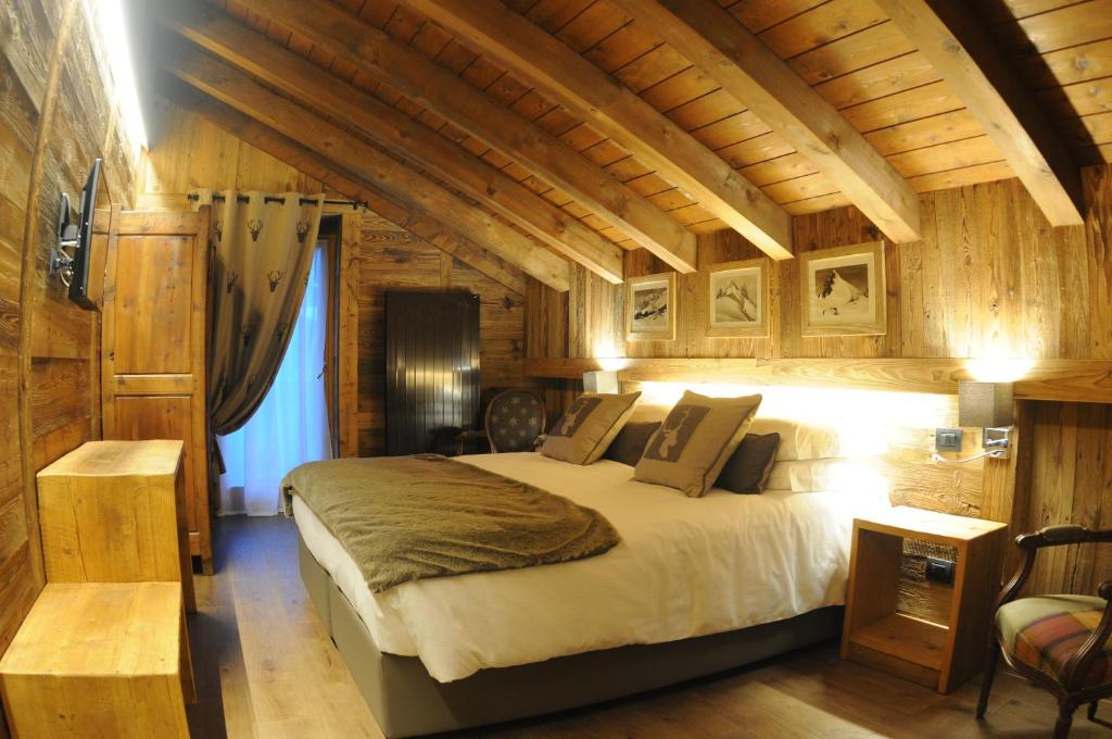 库马约尔L'Abri des Amis的一间带一张大床的卧室,位于带木墙的房间