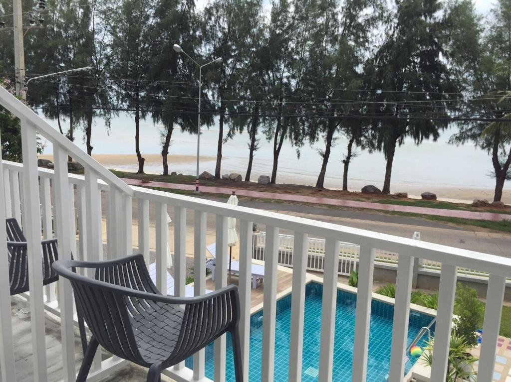盼武里BC夏日海滩旅馆的一个带椅子和游泳池的阳台