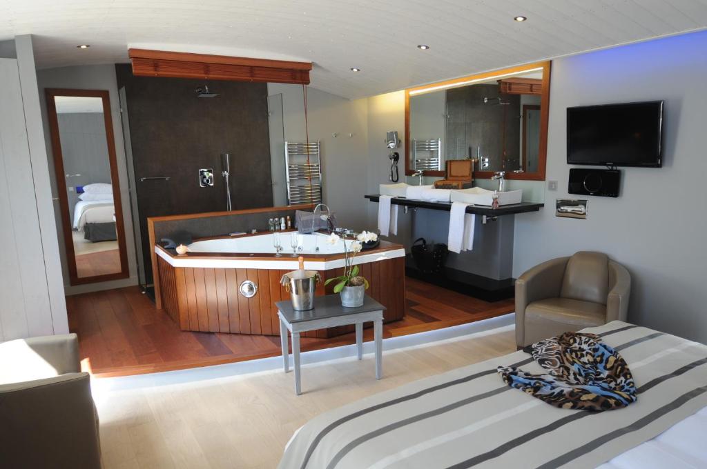 雷岛林滩优雅套房酒店 的一间卧室设有带浴缸的浴室和一张床