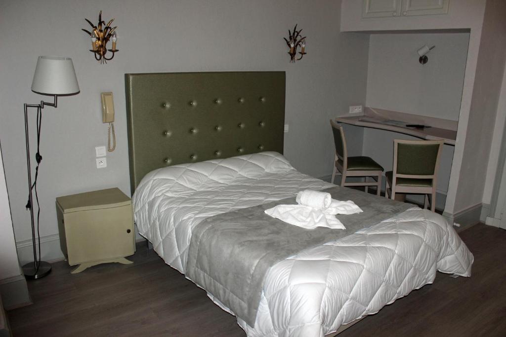 巴拉吕克莱班Hotel restaurant MARTINEZ的一间卧室,配有一张白色花卉床