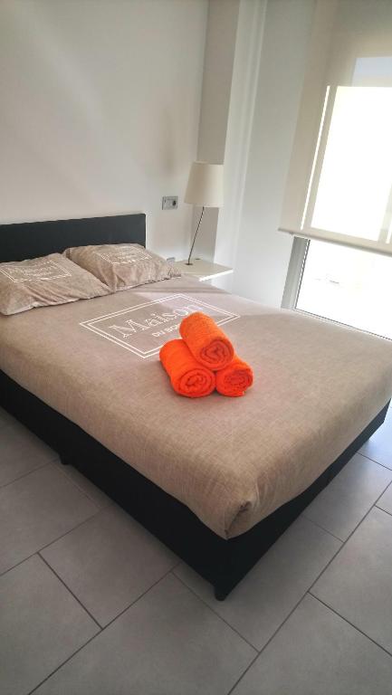 瓜尔达马尔·德尔·塞古拉Apartamentos Marjal 3的床上有两条橙色毛巾