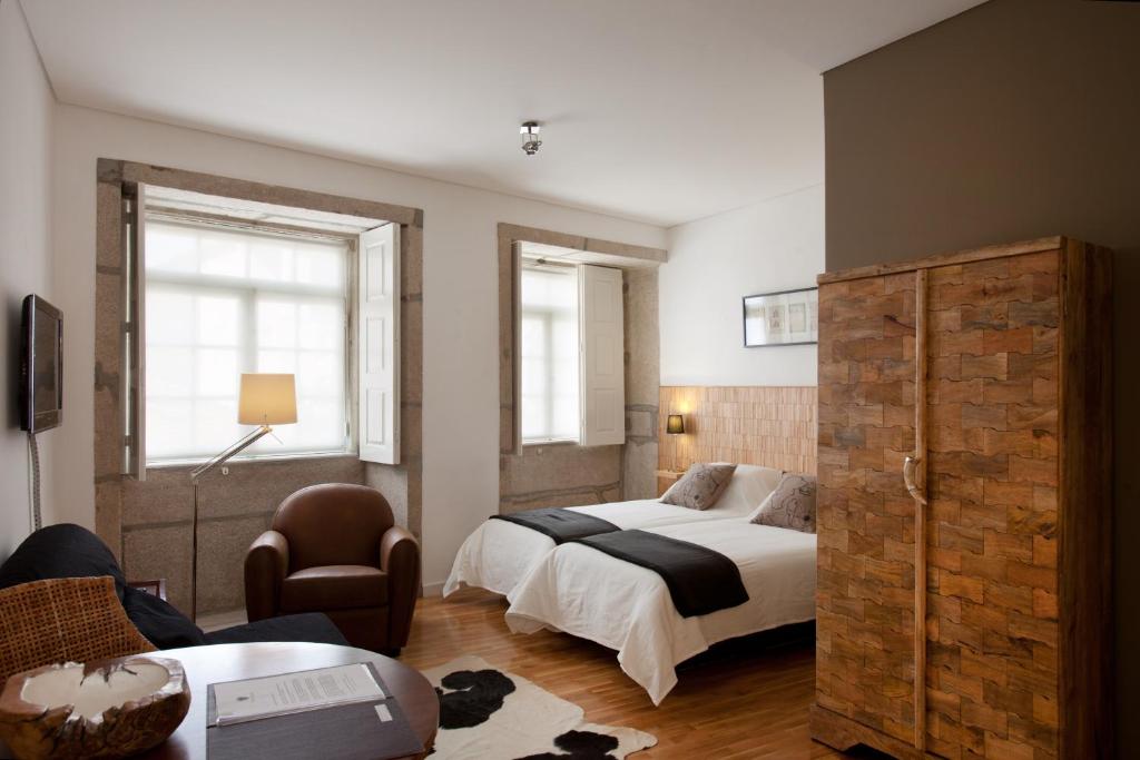 波尔图波尔图森斯滨河公寓的配有一张床和一把椅子的酒店客房