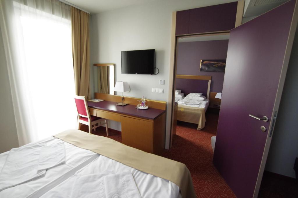 塞克希费黑瓦尔森特盖勒特酒店的酒店客房设有一间带一张床和一张书桌的卧室