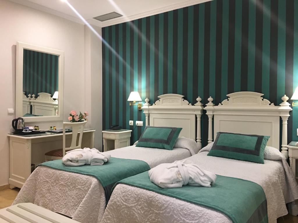 塞维利亚塞维利亚阿德里亚诺精品酒店的一间卧室配有两张带毛巾的床