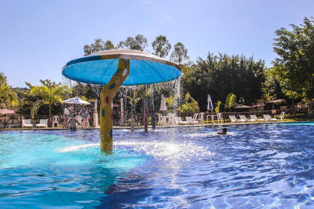 卡舒埃拉斯迪马卡库Hotel Fazenda Chiminelli的游泳池中间有一个喷泉