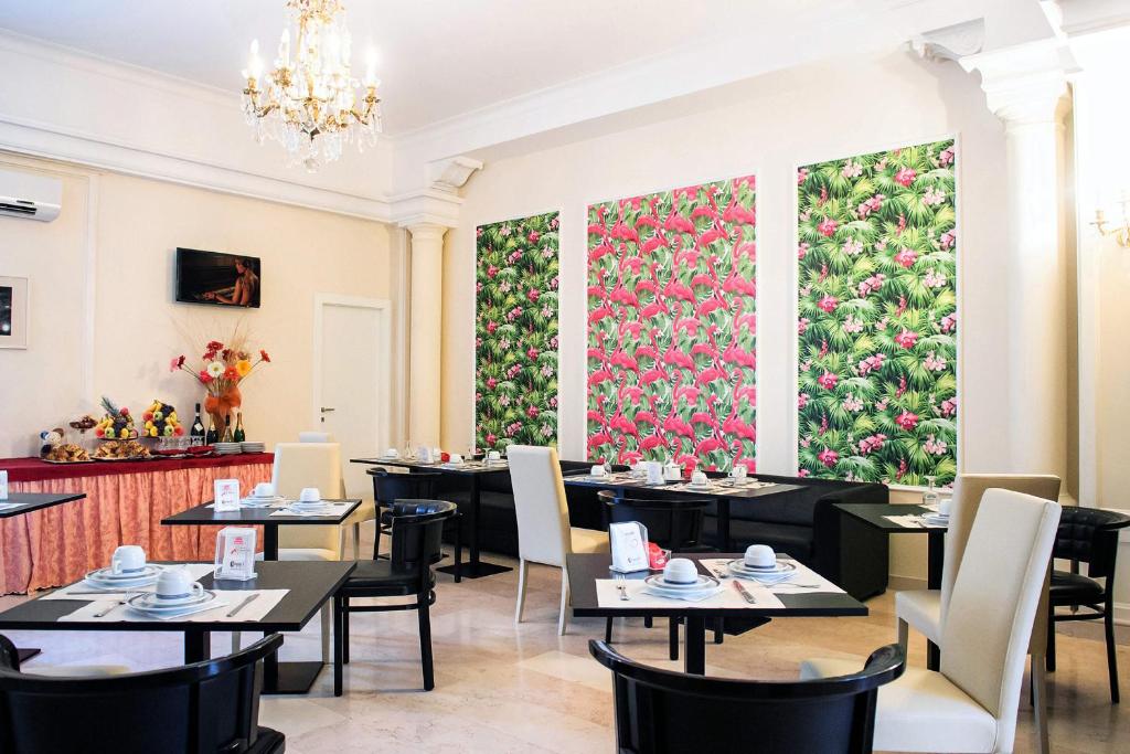 弗罗西诺内Hotel Palombella & Restaurant的餐厅设有桌椅和大型花卉墙