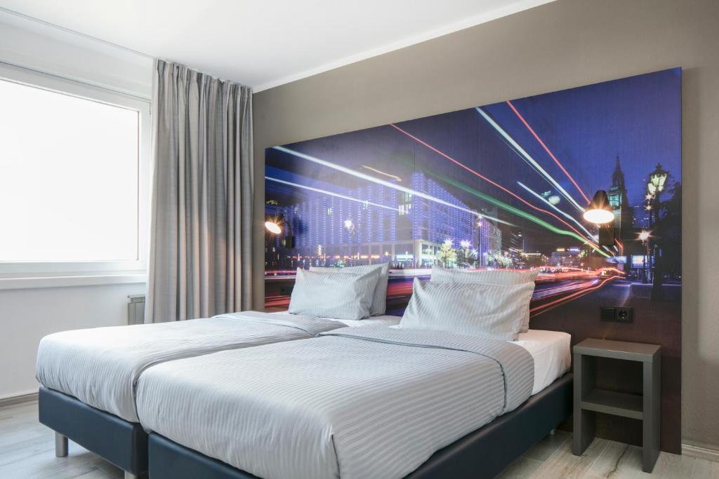 柏林利希腾贝格舒适酒店的一间带两张床的卧室,配有城市绘画