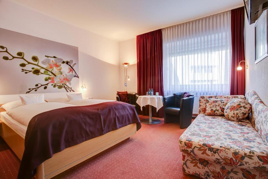 基尔INA Hotel Consul的酒店客房,配有床和沙发