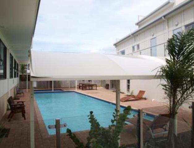 奥克兰奥尔巴尼珀丽汽车旅馆的一个带大白伞的大型游泳池