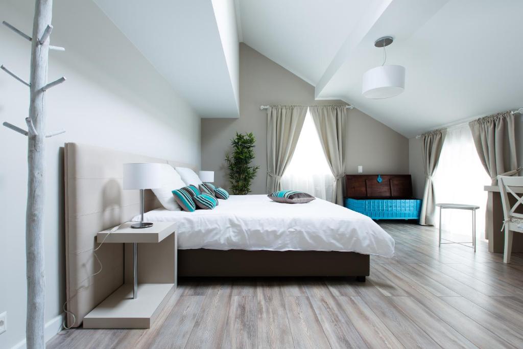 BuchillonAuberge des Grands Bois的卧室配有一张白色的大床,铺有木地板