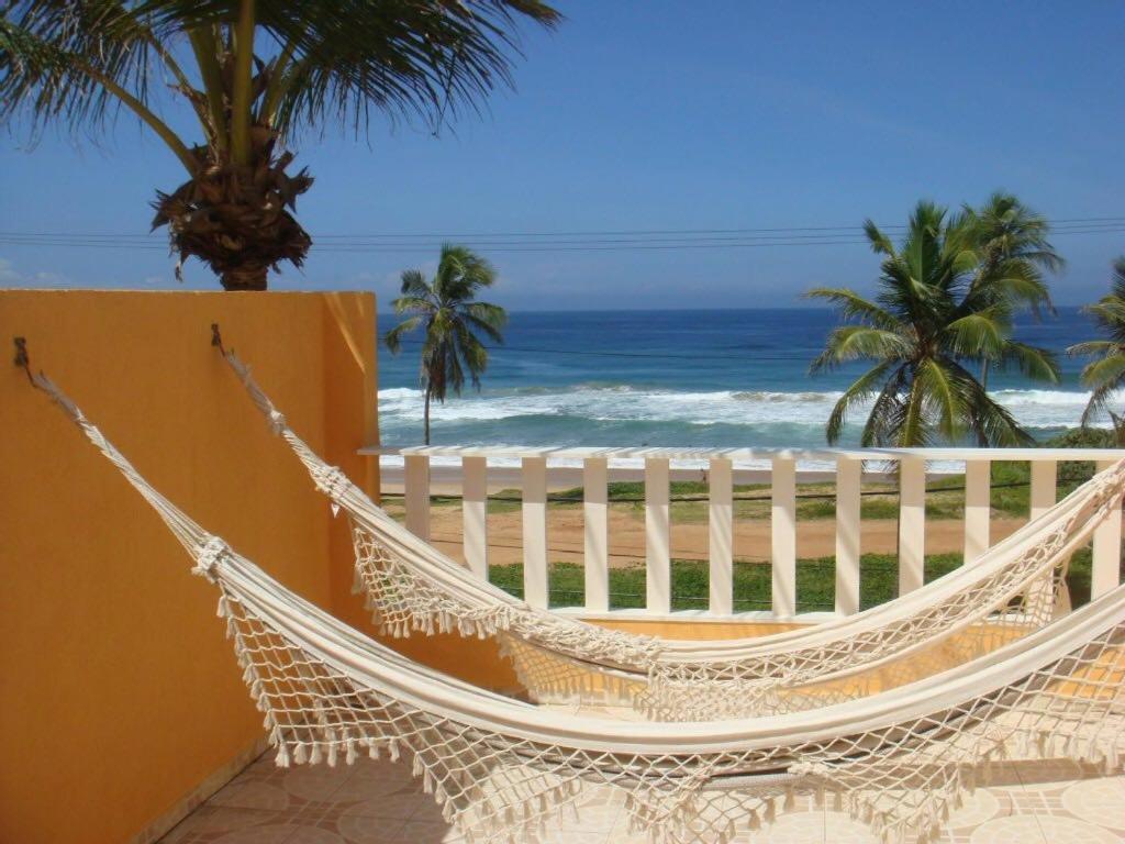 萨尔瓦多Duplex na beira da praia, de frente pro mar的俯瞰海滩的阳台的吊床