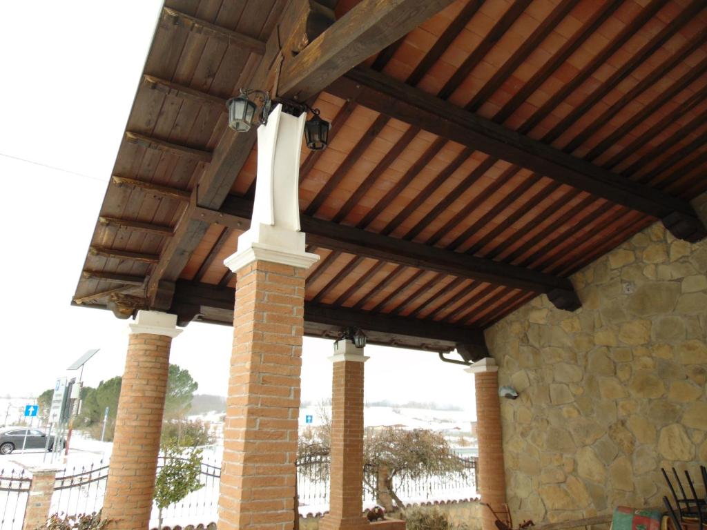 科皮托Agriturismo CHERUBINI DANIELA的砖柱房子的木屋顶