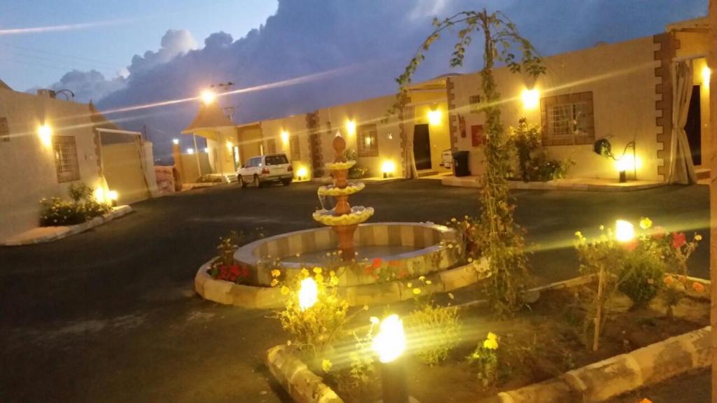 An NimāşTaraf Al Asalah Villas的夜晚在庭院中间的一个喷泉