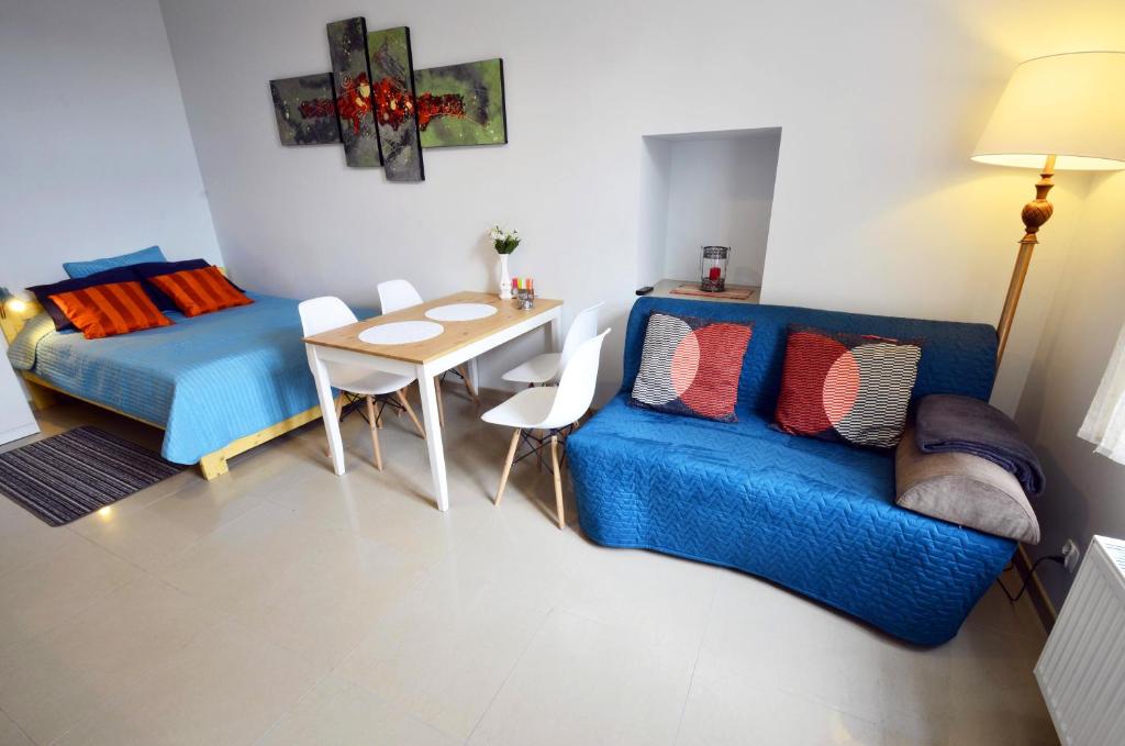 琴斯托霍瓦Studio Aleja 77的客厅配有蓝色的沙发和桌子