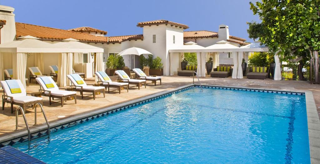 洛杉矶日落侯爵酒店的一个带躺椅的游泳池以及一座房子