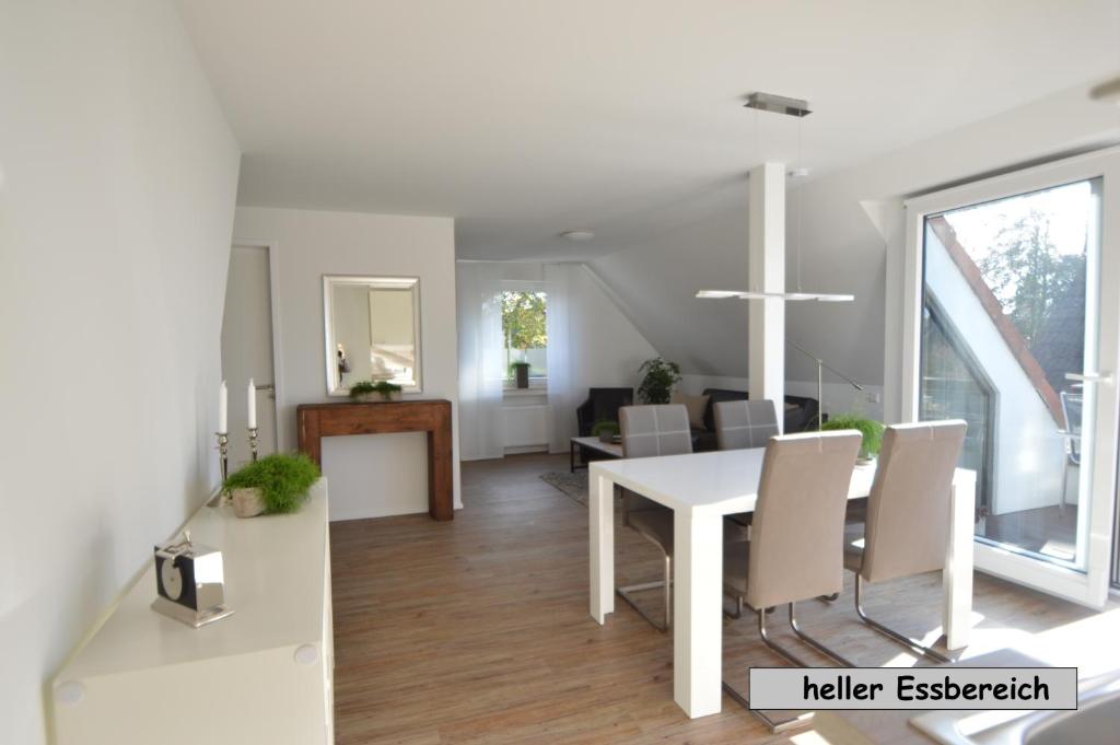 森登霍尔斯特Appartement Sendenhorst的用餐室以及带白色桌椅的起居室。