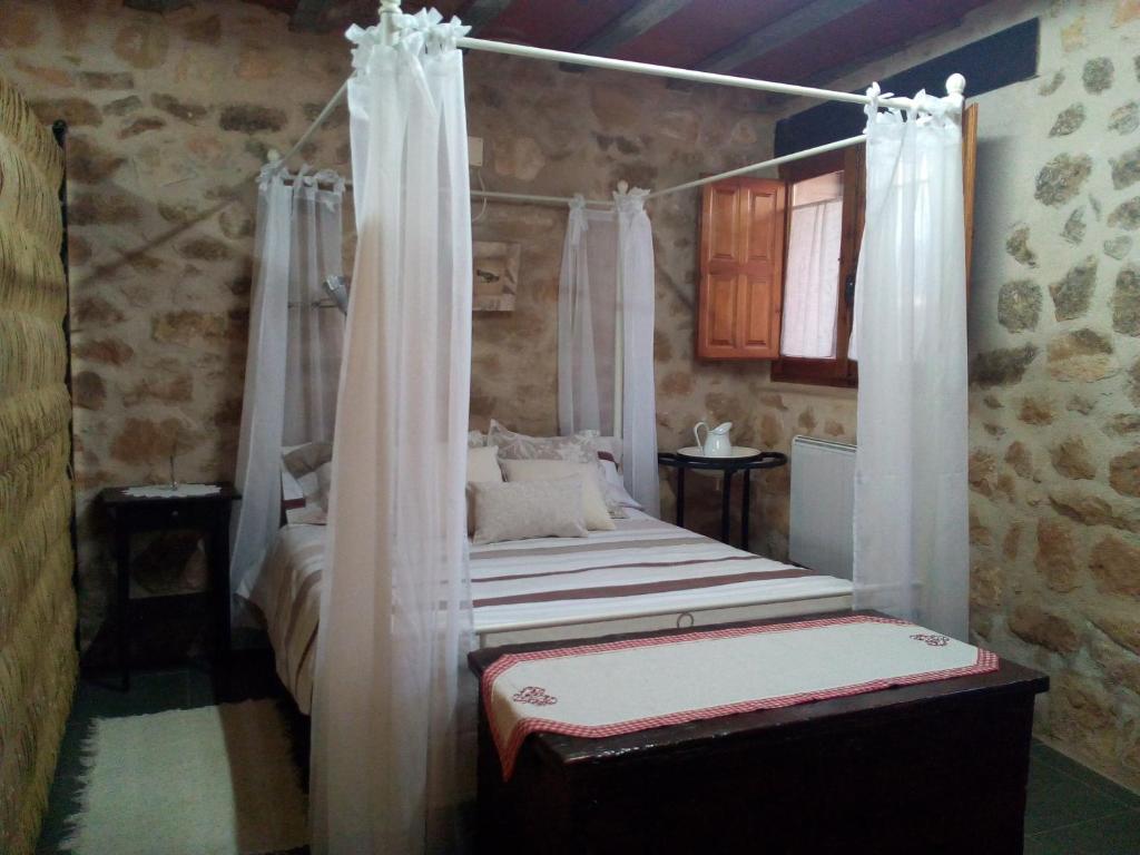 阿尔内斯Casa De Vacances La Vella Era的一间卧室配有一张带窗帘的四柱床