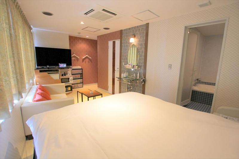 东京U优酒店的一间带白色床的卧室和一间浴室
