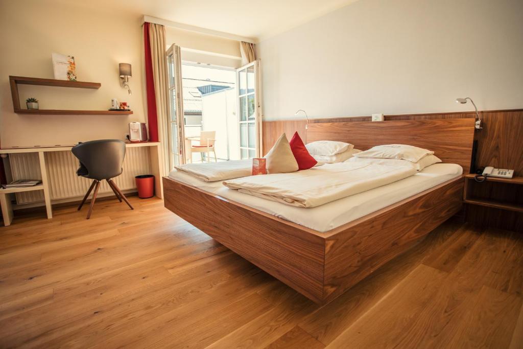 萨尔茨堡罗森维拉酒店的一间卧室配有一张大床和木制床头板