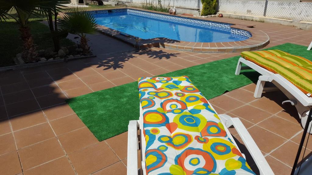 埃勒凡达尔El Vendrell montaña y playa的游泳池前面设有多彩的床垫