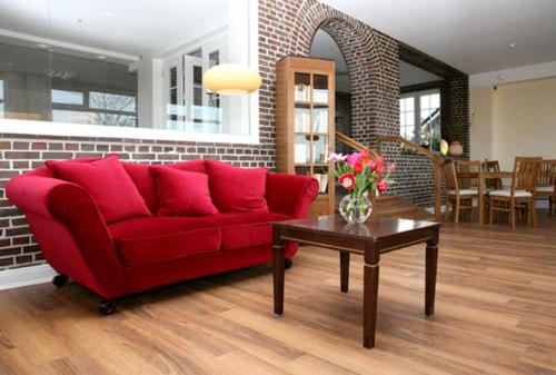 沙博伊茨Haus am Meer的客厅配有红色的沙发和桌子