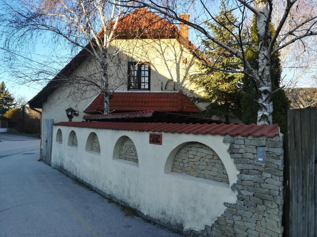 SzentkirályszabadjaVörös Macska Vendégház的白色的建筑,有砖墙和栅栏