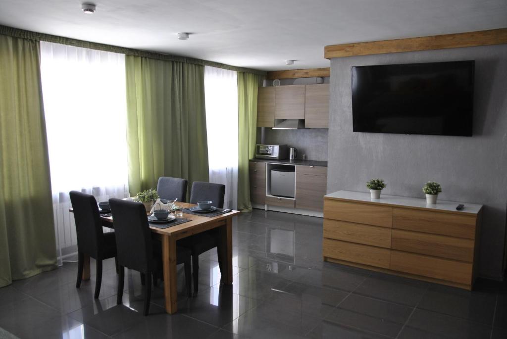 彼尔姆Hotel Albatros的一间带桌椅和电视的用餐室