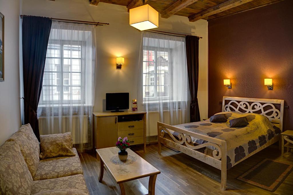 维尔纽斯伯纳蒂努早餐加住宿酒店的一间卧室配有一张床、一张沙发和一把椅子