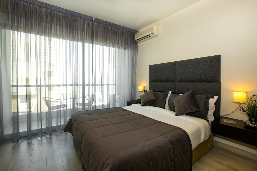 贝鲁特东方女王之家公寓式酒店 的一间卧室设有一张大床和一个大窗户