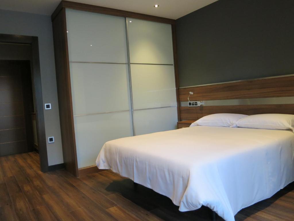 奥维多克拉林公寓酒店的卧室配有白色的床和大衣柜。