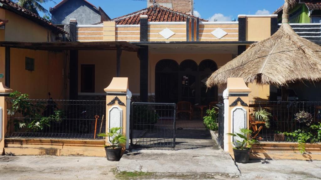 卡里蒙贾瓦Arriani Homestay的一座带门和茅草屋顶的房子