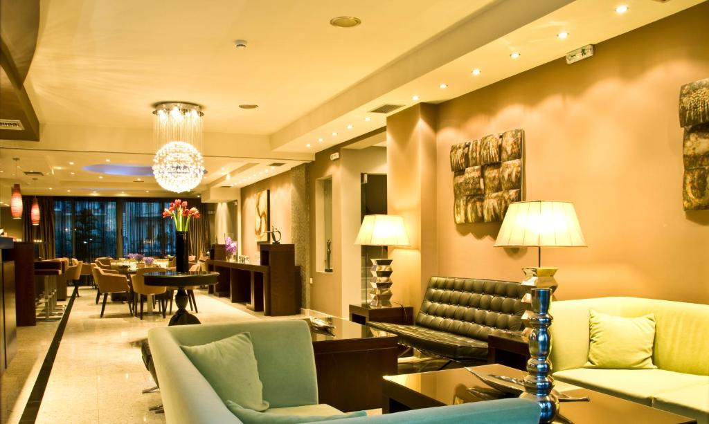 纳弗帕克托斯Flisvos Hotel Nafpaktos的酒店大堂设有沙发和桌椅