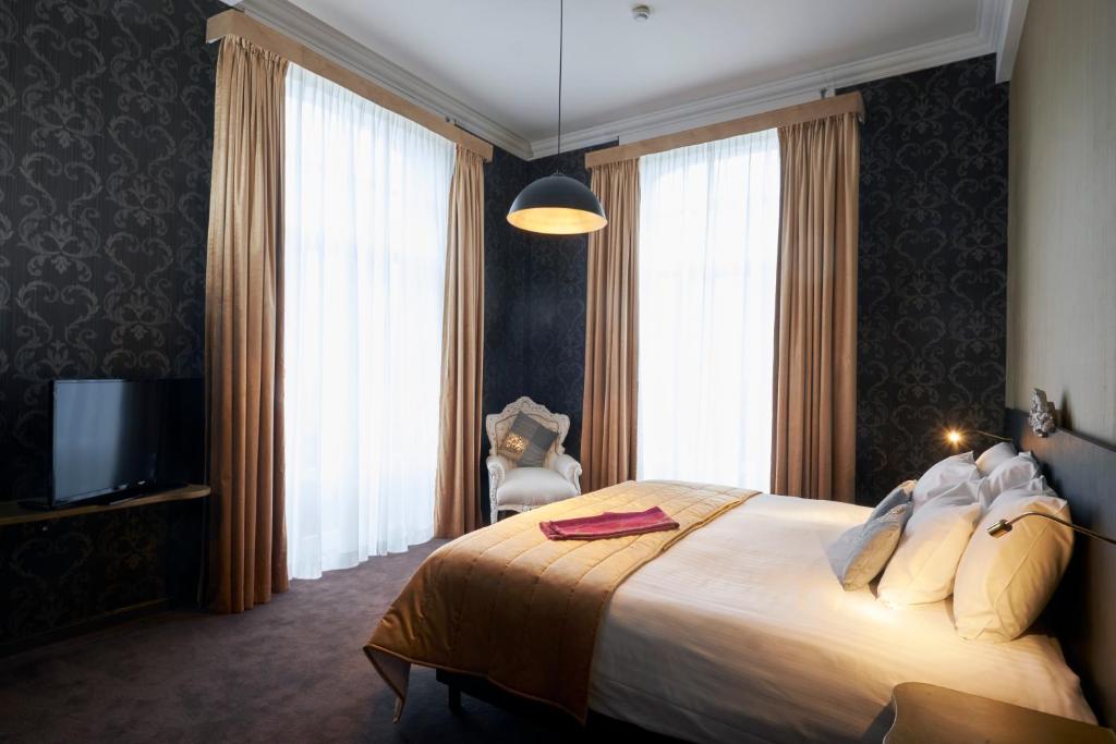 那慕尔娜姆尔城堡酒店的一间卧室配有一张大床和电视