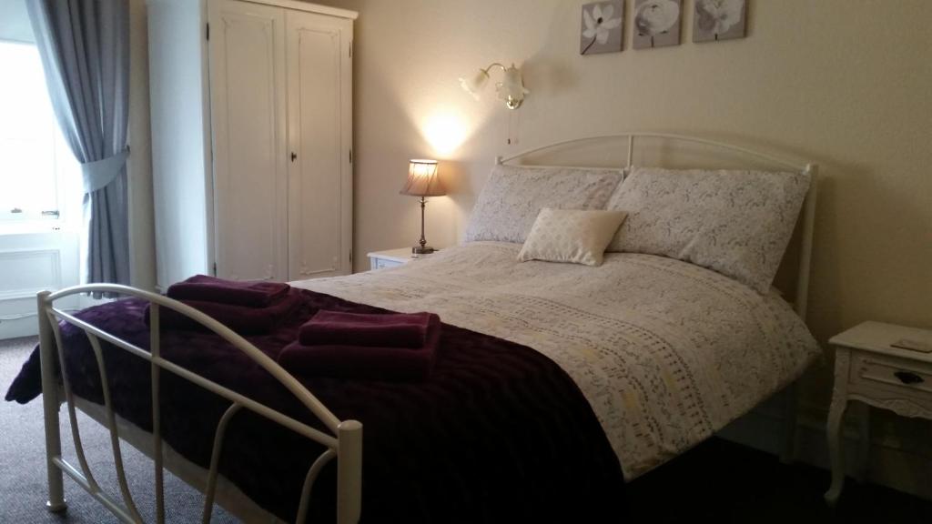 斯特兰拉尔Blue Peter hotel的卧室配有带白色棉被的床