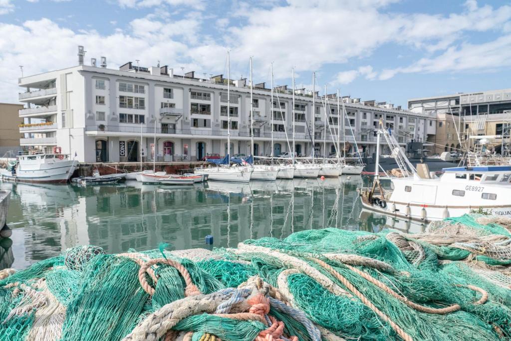 热那亚Darsena Apartment的一群船停靠在港口,有一座建筑