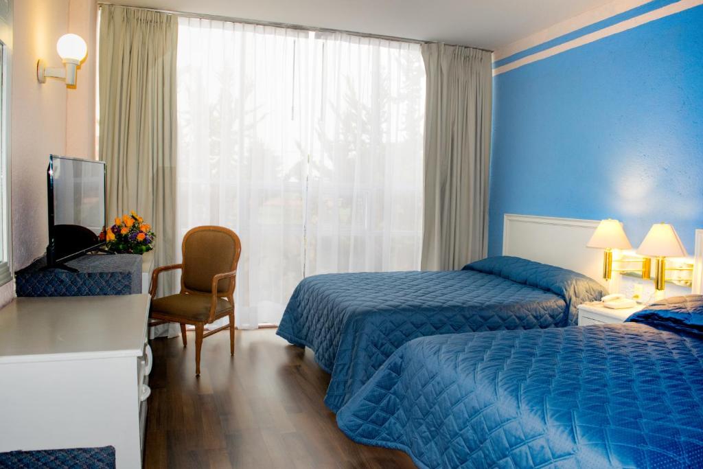 托卢卡旧金山酒店的酒店客房设有两张床和电视。