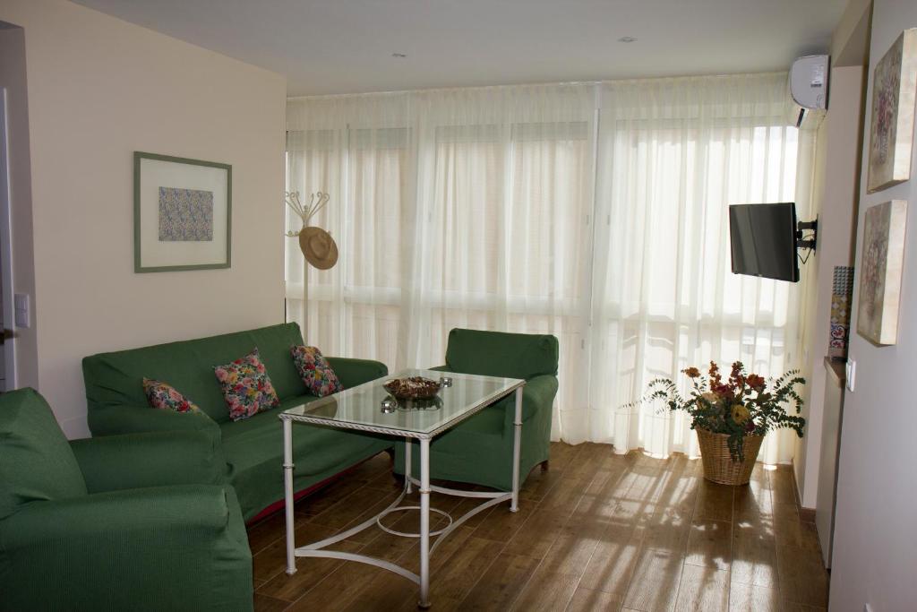 桑卢卡尔-德巴拉梅达Infanta Beatriz的客厅配有绿色沙发和桌子