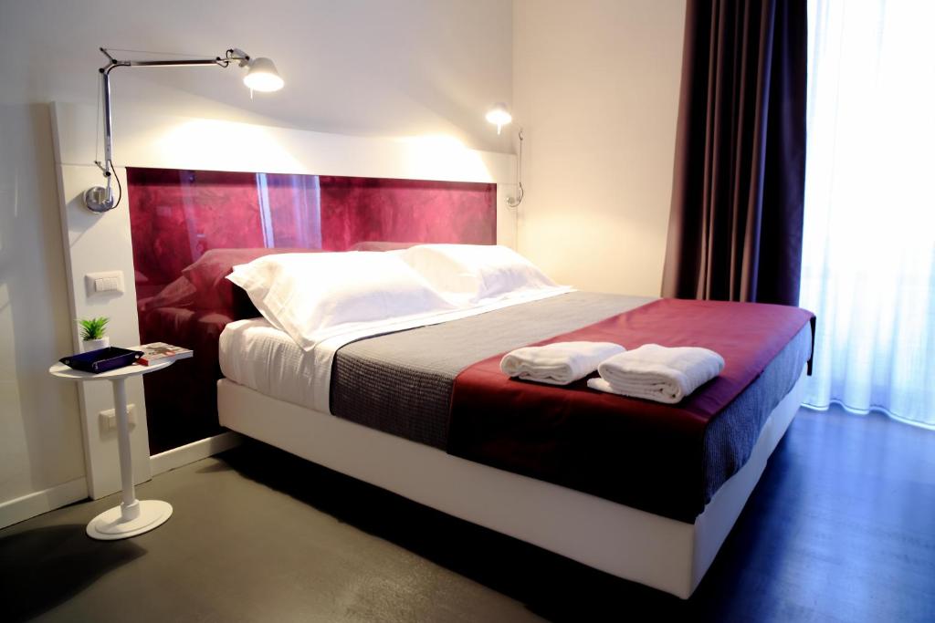 罗马乌贝斗兽场酒店的一间卧室配有一张床,上面有两条毛巾